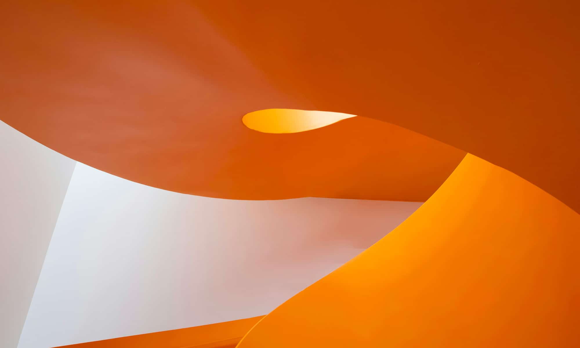 Formes architecturales cuivrées et blanches symbolisant la créativité et la fluidité de la communication visuelle.